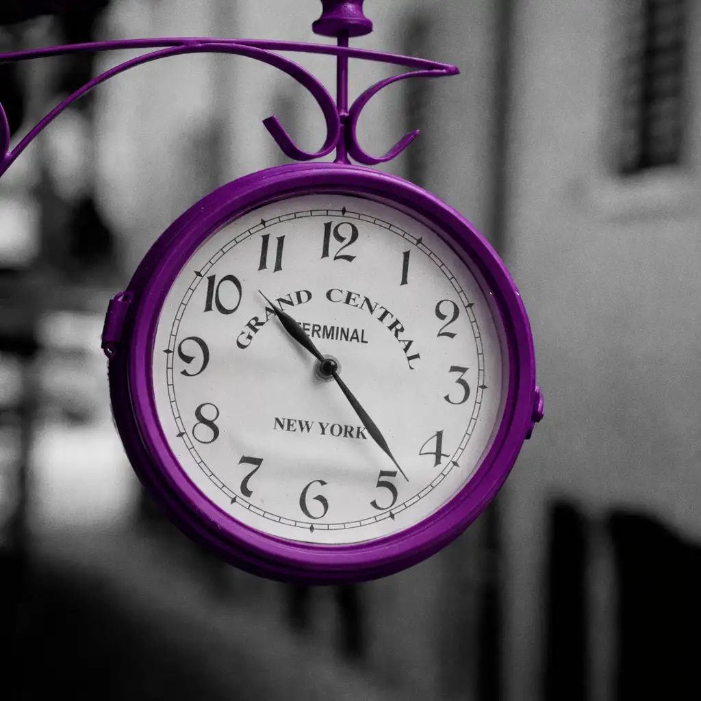 Reloj de manecillas púrpura antiguo que refleja los horarios de atención de SuSanaSer